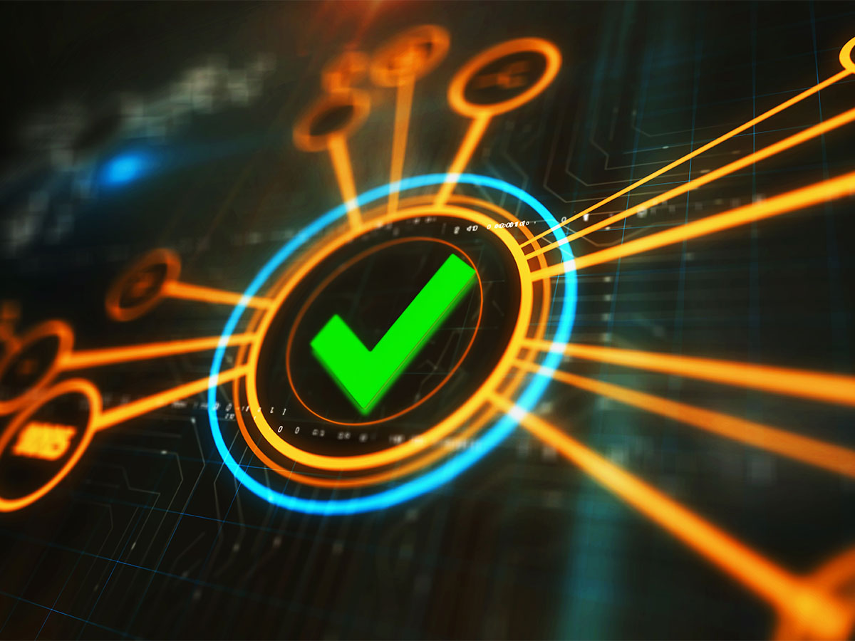 Cyber Assurance concept image: dynamic green tick symbol on a dark computer screen.